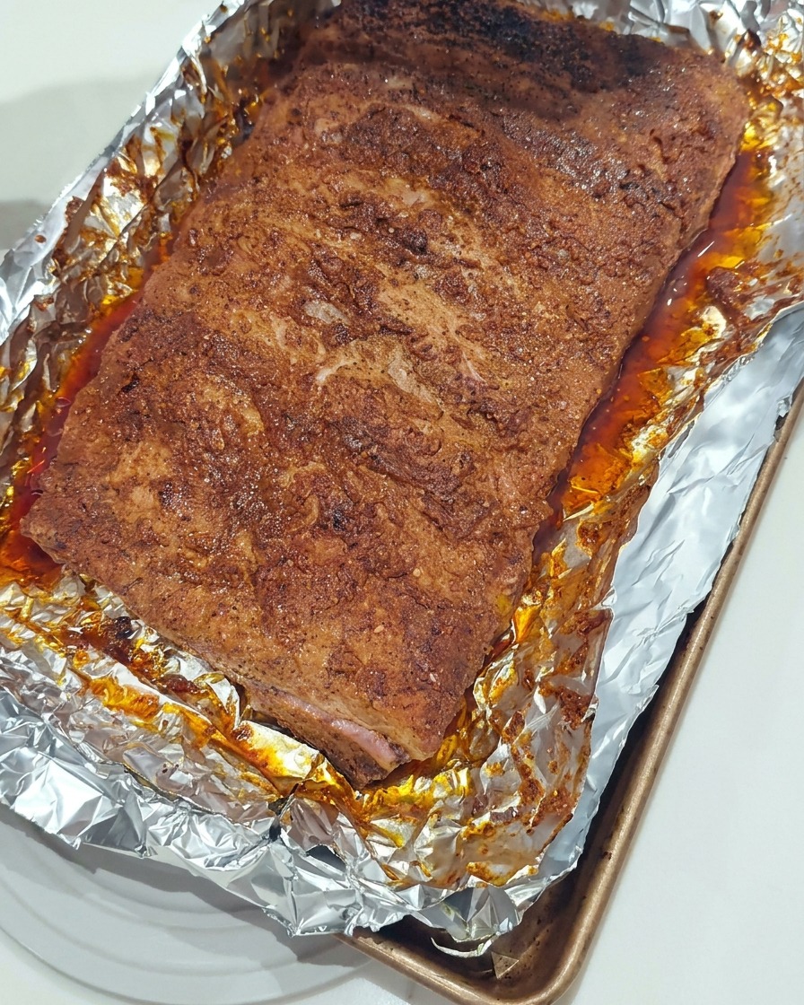 실리콘 브러시로 구워진 폭립 표면에 BBQ 소스를 덧바르는 모습.