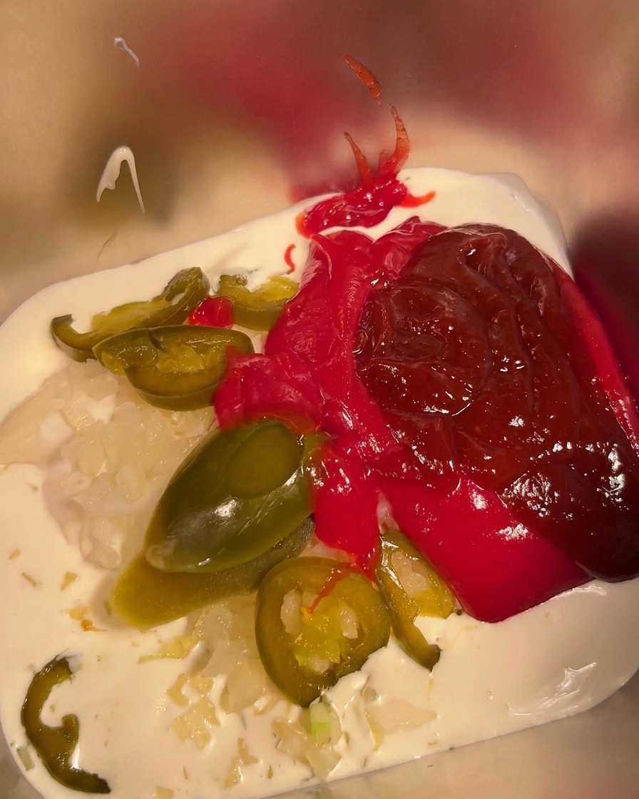 용기 안의 재료들에 칠리 파우더를 뿌리는 모습.