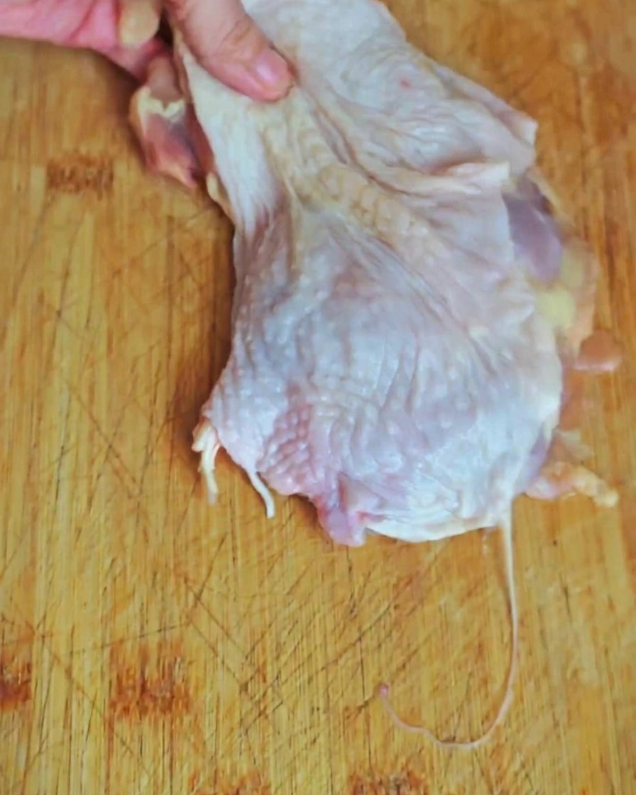 도마 위에서 닭다리 살을 한입 크기로 썰고 있는 모습.