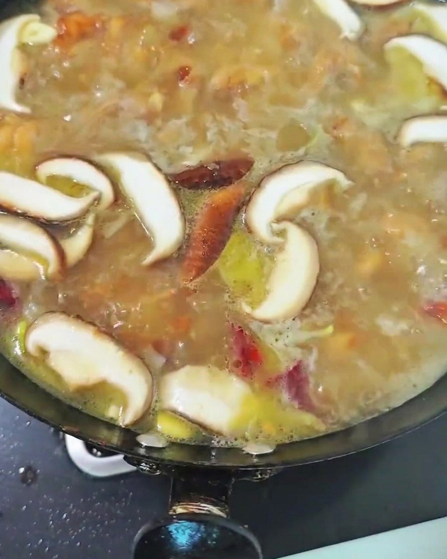 육수에 썰어둔 표고버섯을 넣고 끓이는 모습.