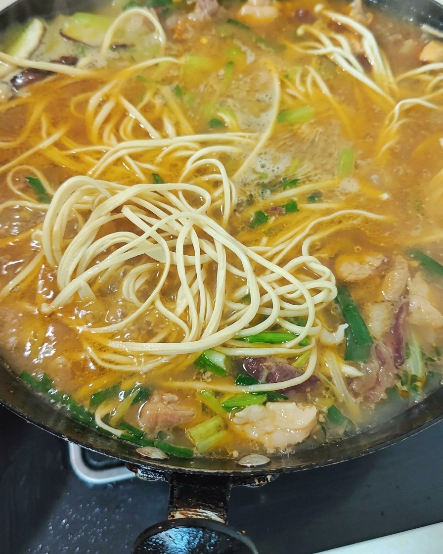 마지막에 푸른 채소와 마늘종을 넣어 마무리하는 모습.