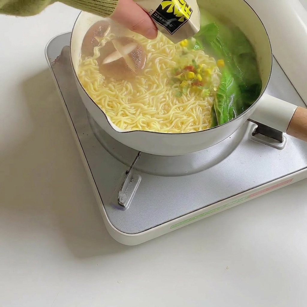 완성된 국수 요리에 후레이크를 뿌리는 모습.