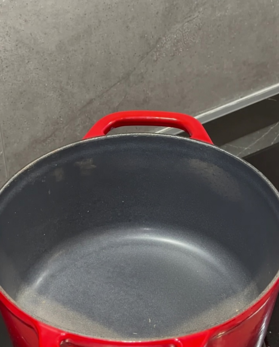 가스레인지 위 빨간 냄비에서 버터가 녹고 있는 모습.