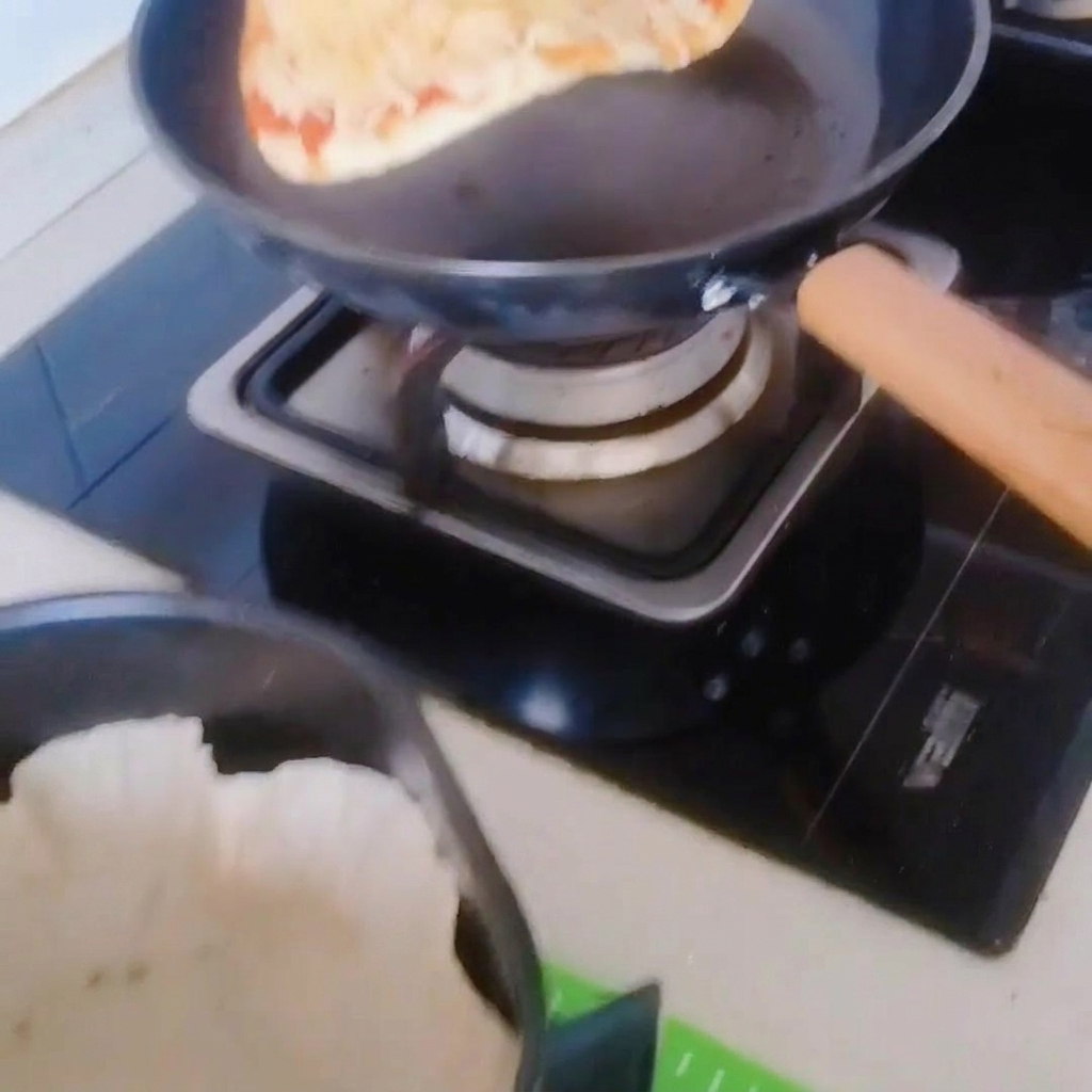 프라이팬에서 종이 호일을 깐 에어프라이어 바스켓으로 피자를 옮기는 모습.
