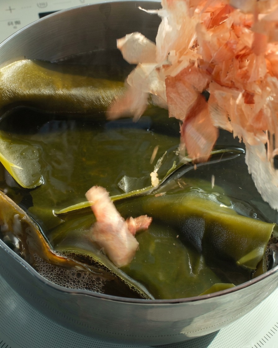 뜨거운 다시마 육수가 담긴 냄비에 가쓰오부시를 넣는 모습.