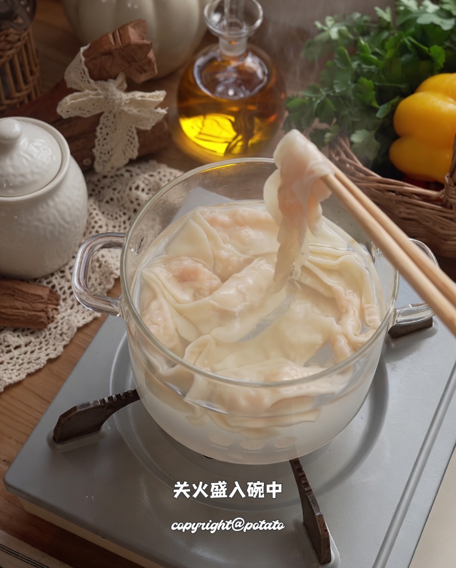 젓가락으로 삶은 새우 면을 건져 그릇에 담는 모습.