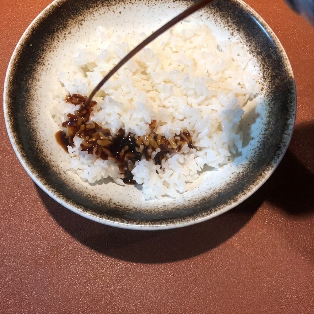 따뜻한 흰 밥 위에 준비한 텐동 소스를 골고루 뿌리는 모습.