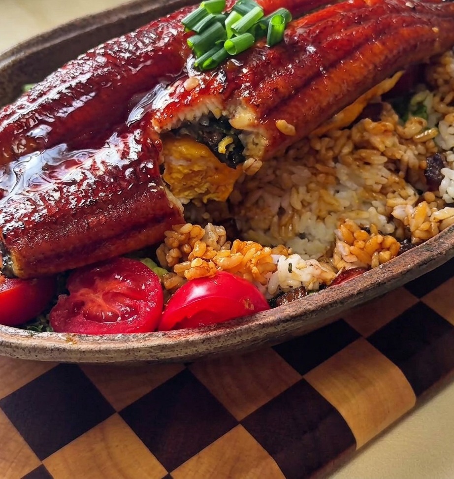 밥 위에 소스를 숟가락으로 끼얹는 모습