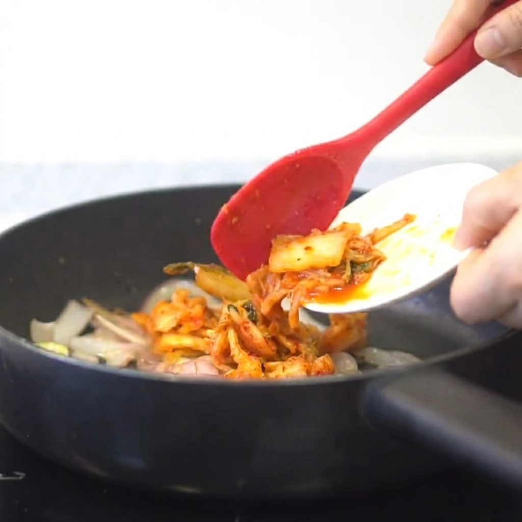 볶아진 채소와 함께 팬에 김치를 넣고 볶는 모습.
