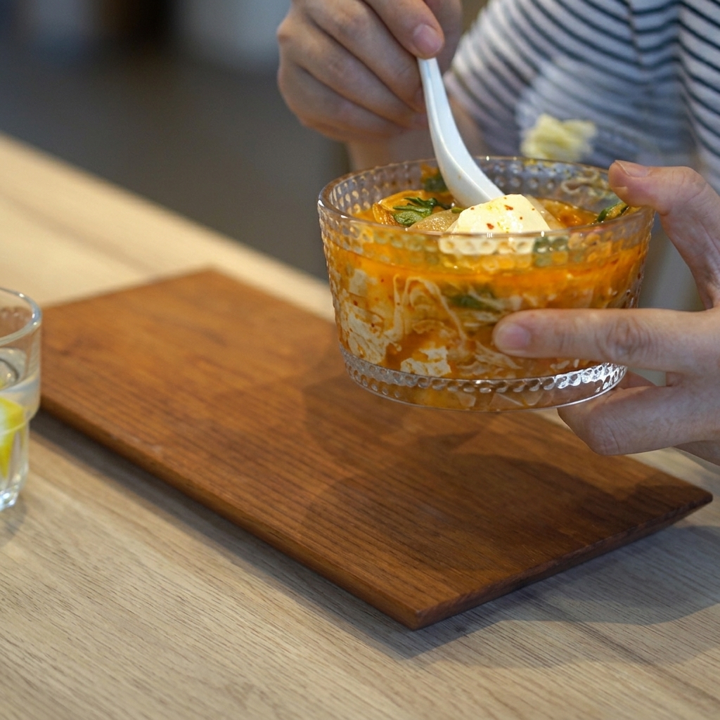 김치찌개 국물에 손질한 팽이버섯을 넣는 모습.
