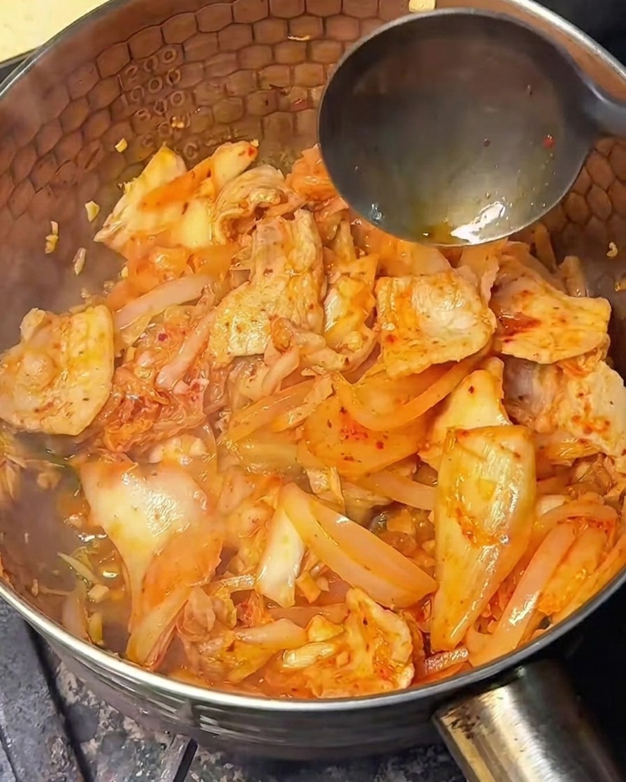 볶은 재료에 진간장을 넣어 간을 맞추는 모습.