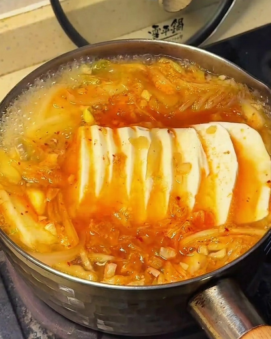 두부찌개 위에 소금과 설탕을 뿌려 간을 맞추는 모습.