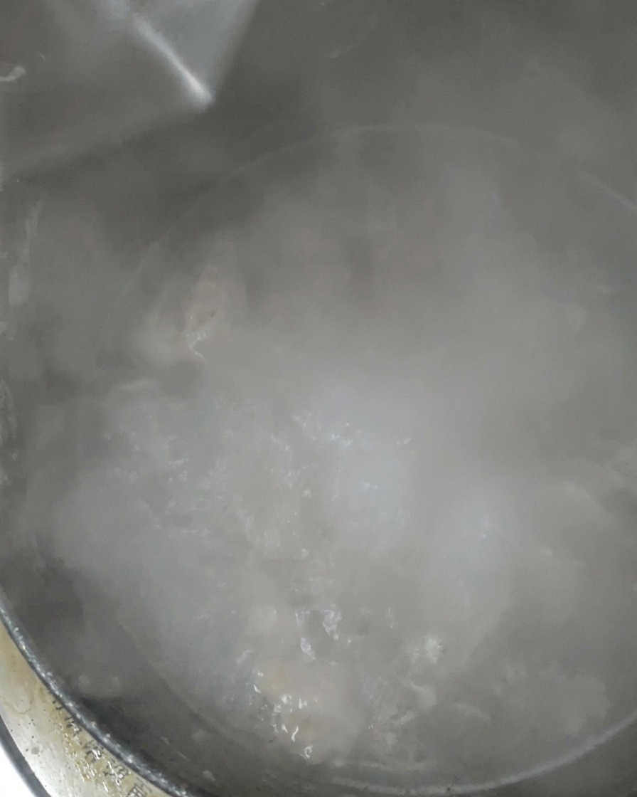 보글보글 끓는 찌개에 물을 추가하는 모습.