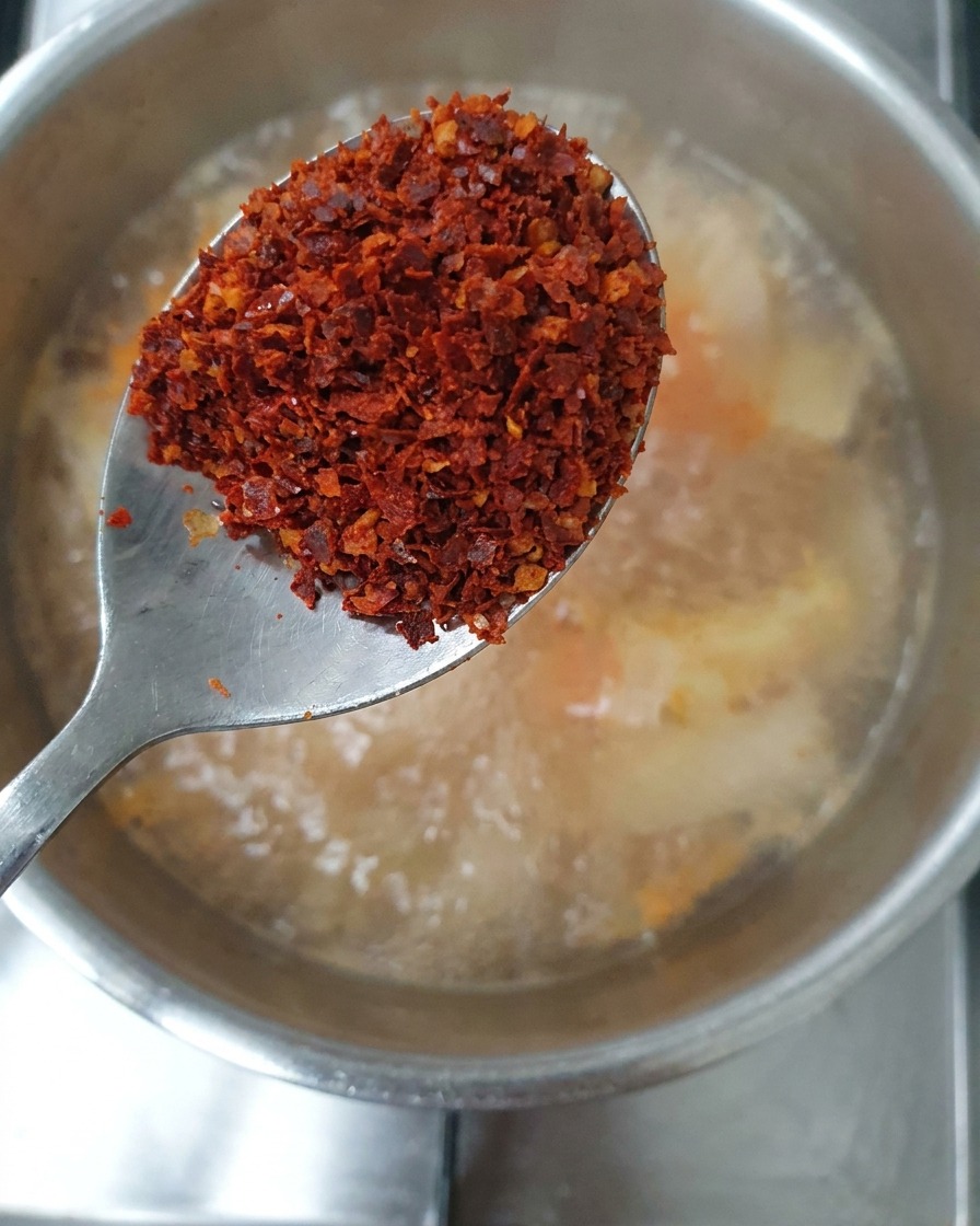 고춧가루를 찌개에 뿌리는 모습.