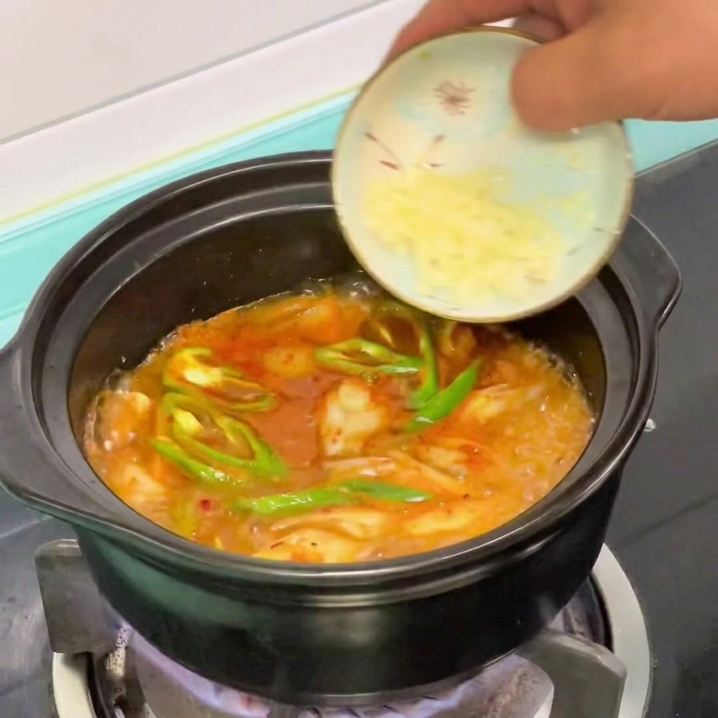거의 다 끓은 순두부찌개에 다진 마늘을 추가하는 모습.