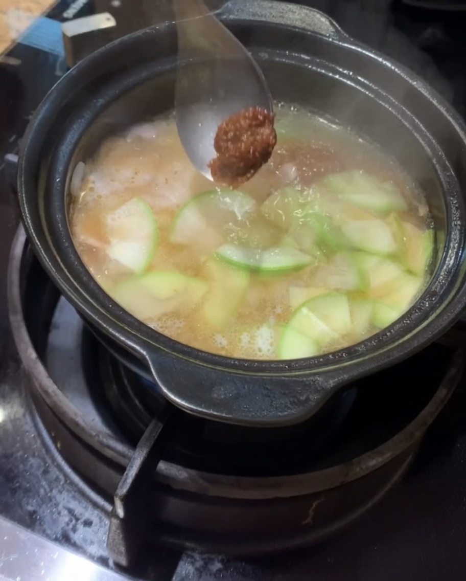 끓는 육수에 된장과 고추장을 풀어 넣는 모습.