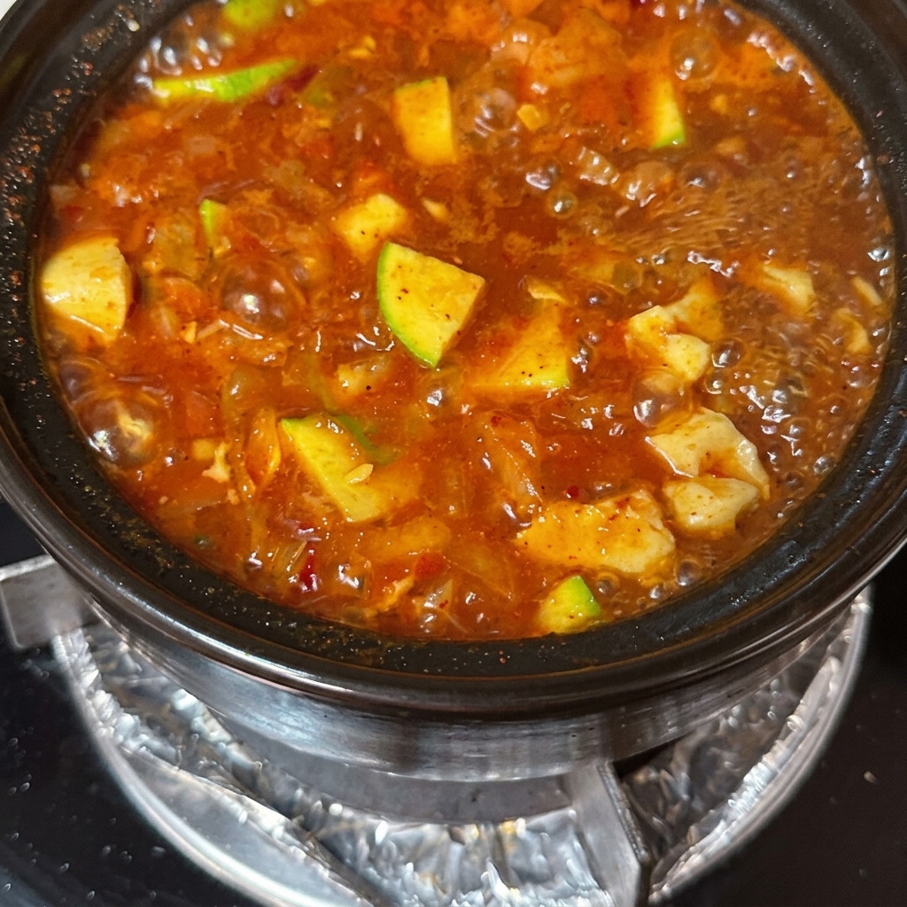 찌개 위로 소고기와 달걀을 올리는 모습