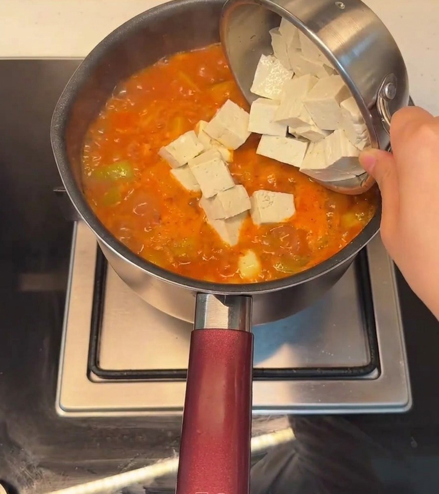 팔팔 끓는 찌개에 큼직하게 썬 두부를 넣는 모습.