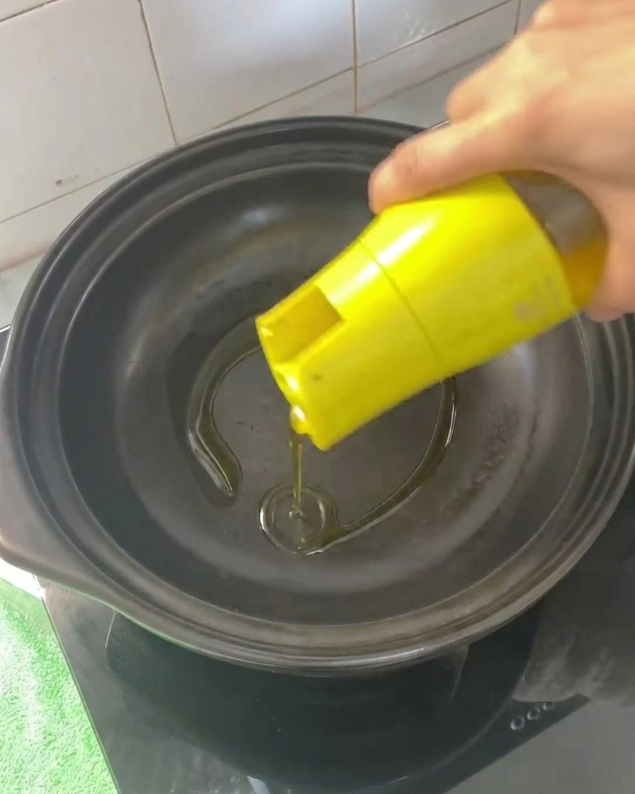 가열된 뚝배기에 식용유를 두르는 모습.