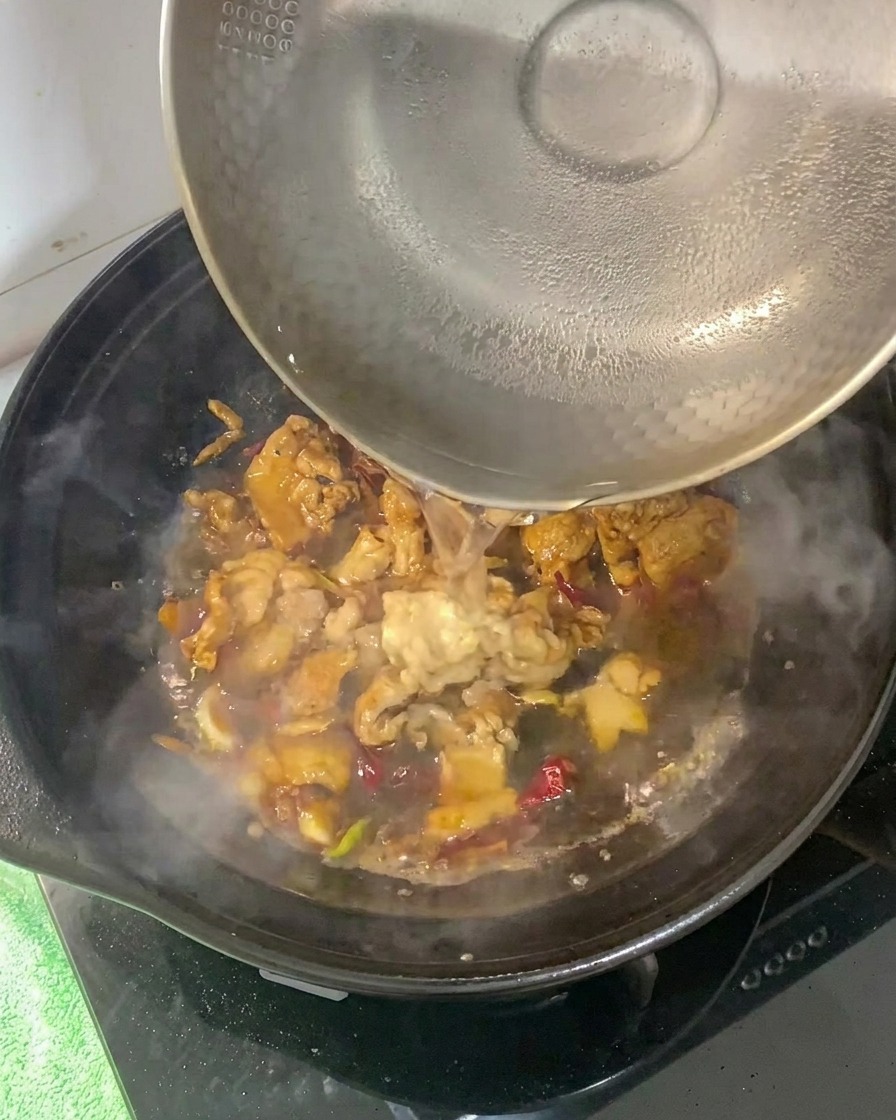 양념된 삼겹살 베이스에 뜨거운 물을 붓는 모습.