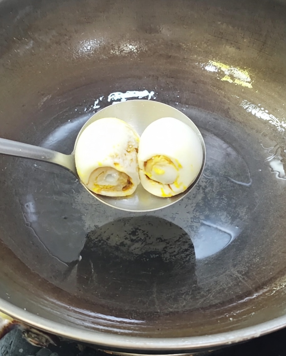 뜨거운 기름을 두른 웍에서 지글거리며 볶아지는 염장 오리알.