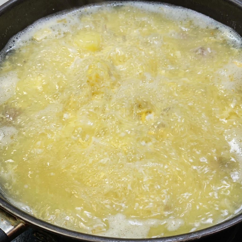 끓는 두부와 염장 달걀 육수에 소금과 백후추로 간을 하는 모습.