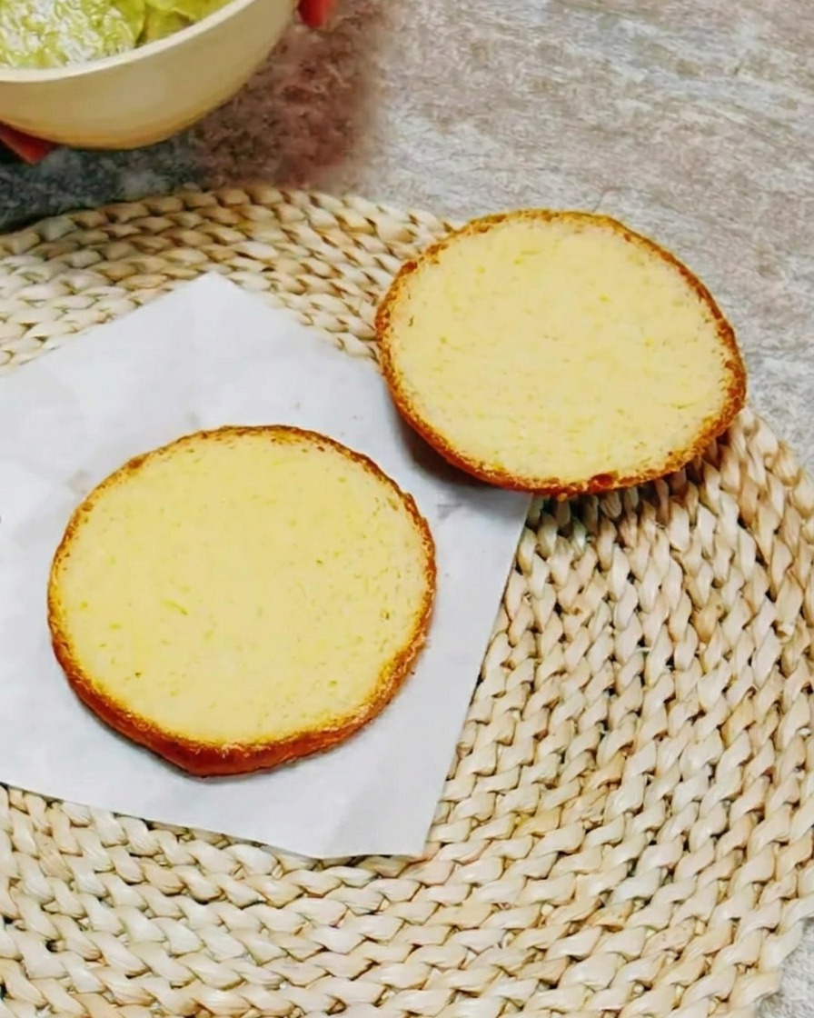 크리미한 녹색 허브 소스가 발라진 버거 번의 단면.
