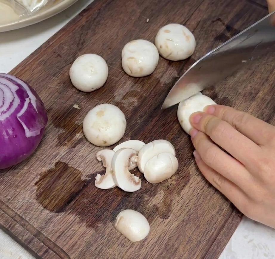 도마 위에서 가지런히 슬라이스 된 신선한 양송이버섯.