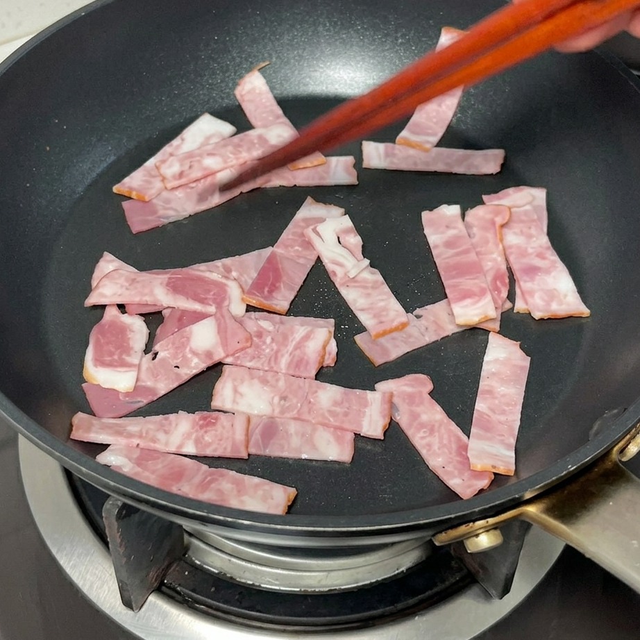 팬에서 노릇하게 구워지고 있는 베이컨.