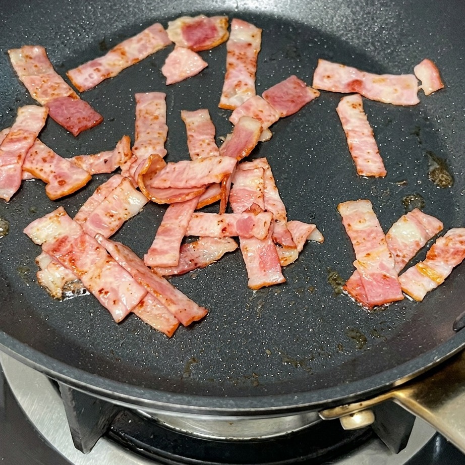 구운 베이컨이 있는 팬에 버터를 넣고 녹이는 모습.