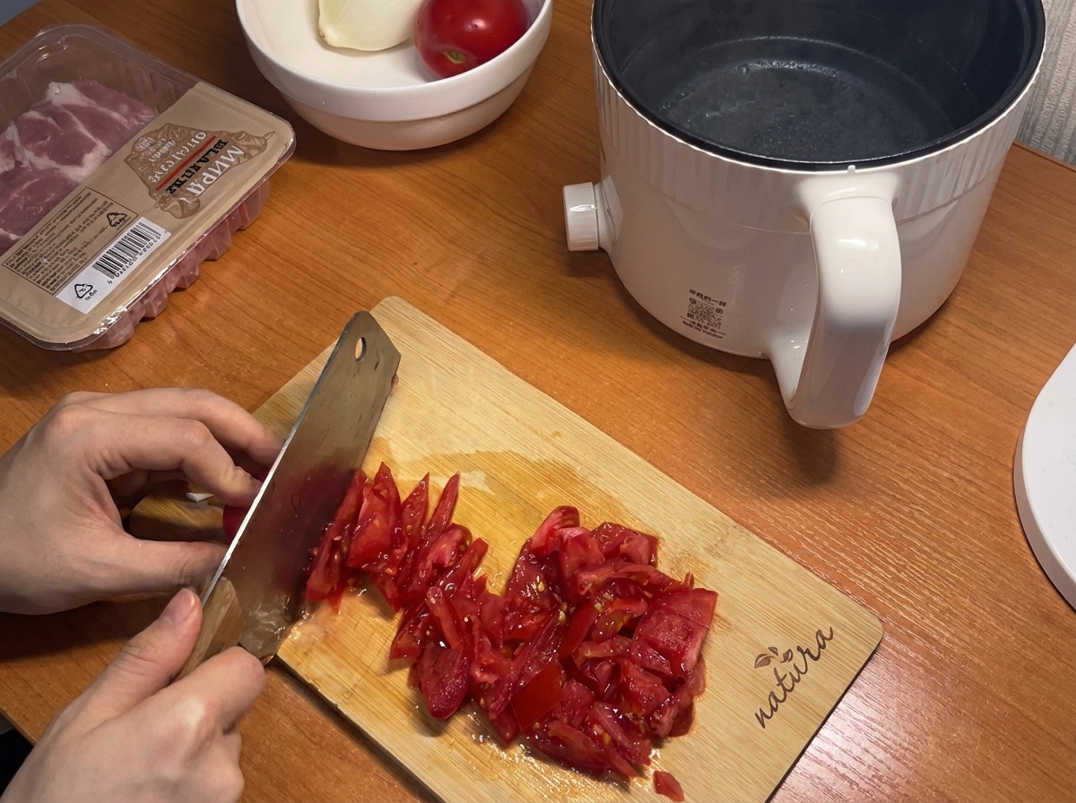 도마 위에서 신선한 붉은 토마토를 작은 크기로 써는 모습.