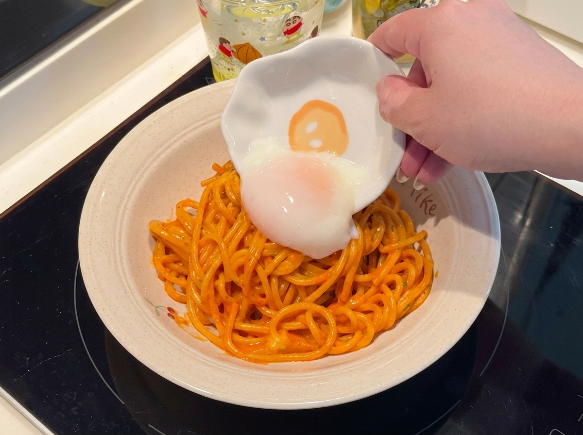 파스타 위에 반숙란을 올리는 모습.