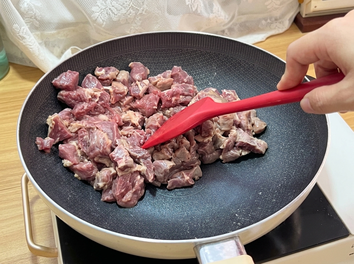 팬에서 소고기 큐브가 지글거리며 갈색으로 잘 익어가는 모습.