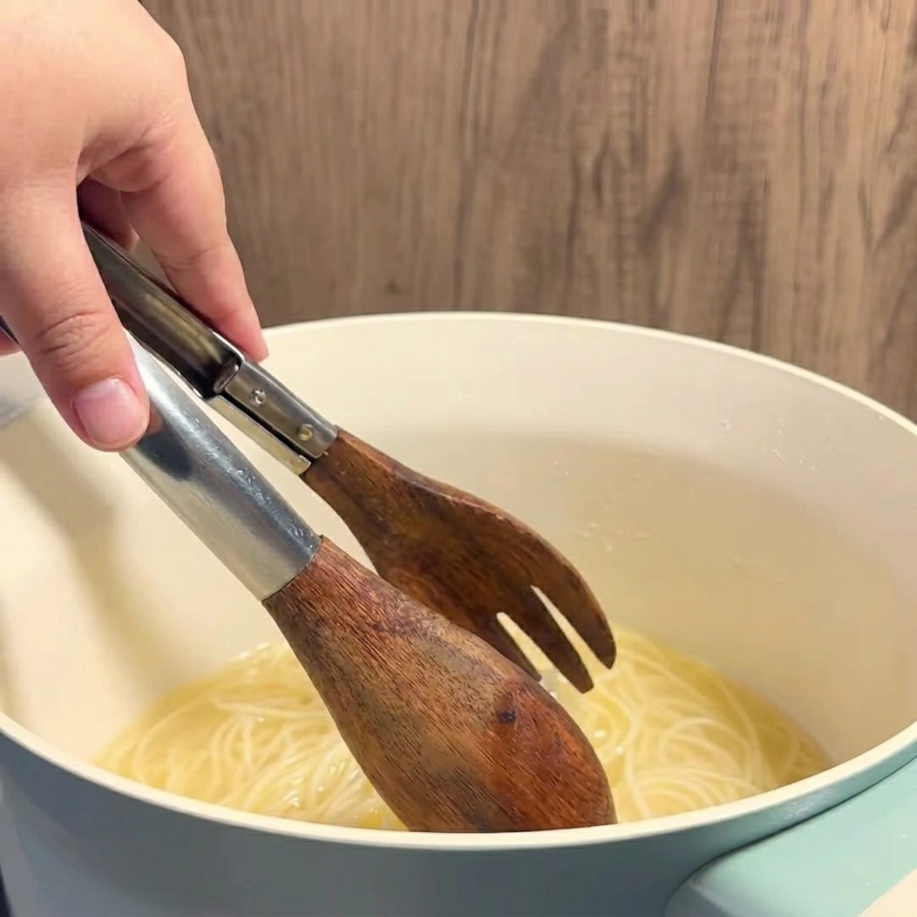 뜨겁고 노란 버터 옥수수 육수를 투명한 유리잔에 국자로 떠 넣는 모습.