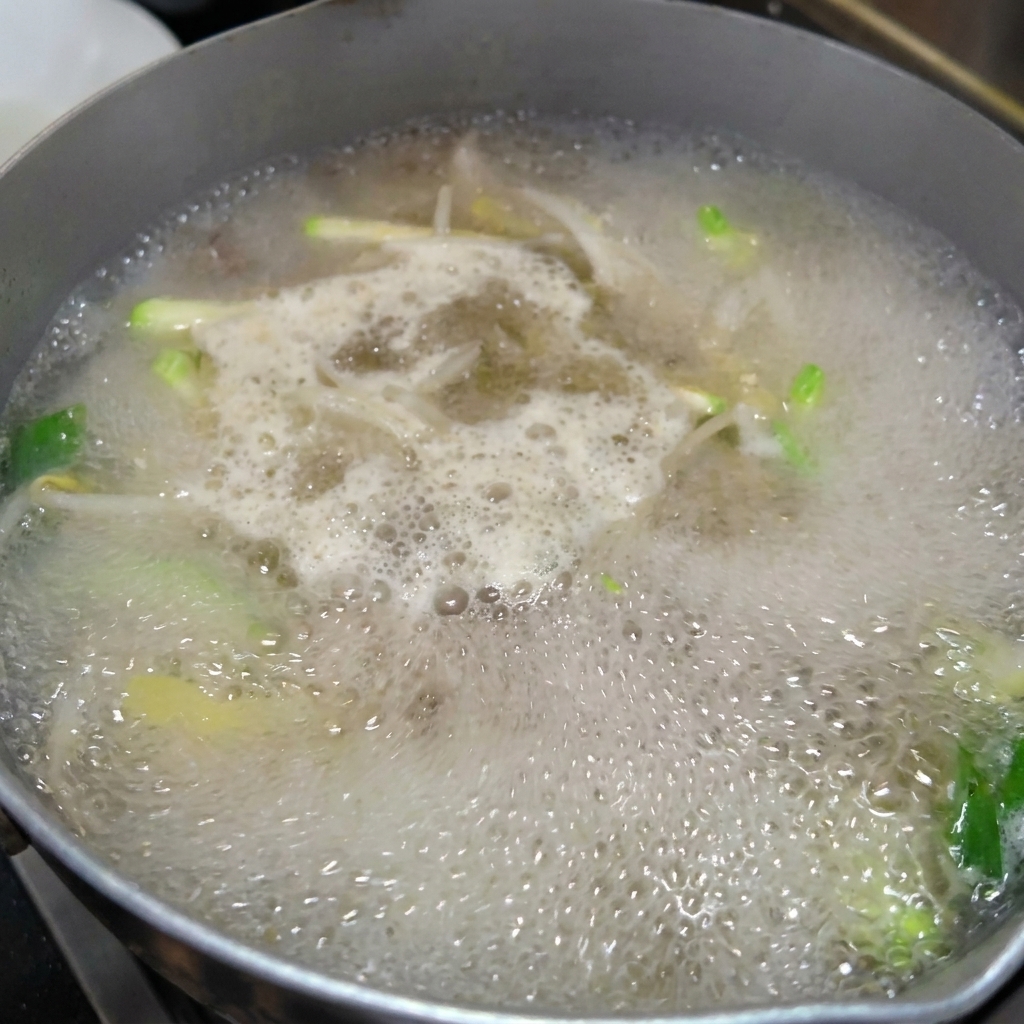 끓는 육수에 칼국수 면을 넣는 모습.