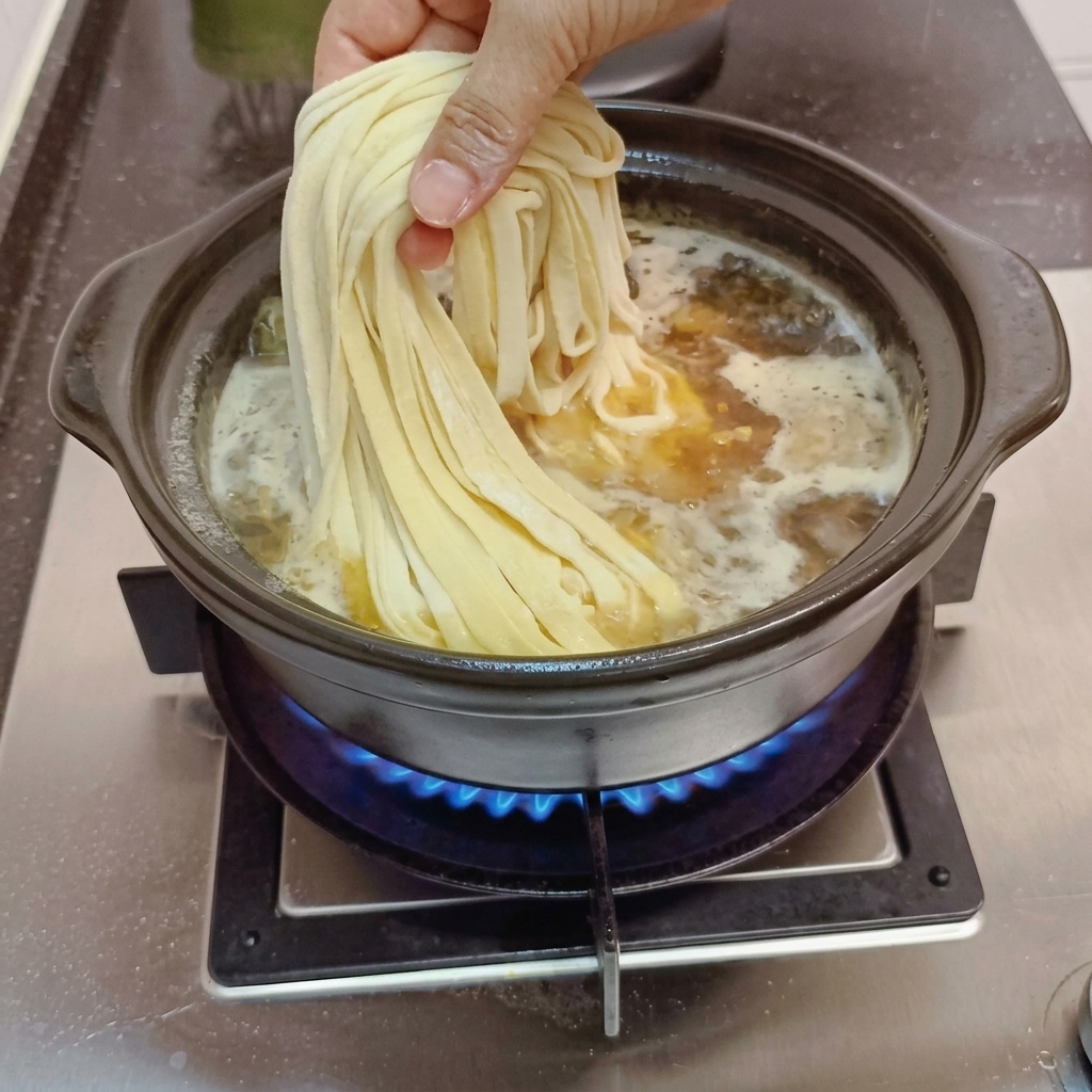 끓고 있는 국물에 수제 국수를 넣는 모습.