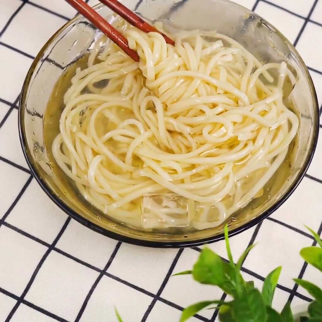 삶아진 면을 젓가락으로 건져내는 모습