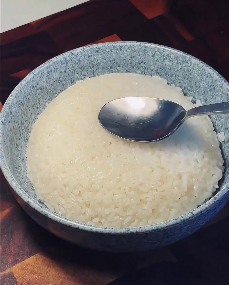 그릇에 담긴 밥 중앙을 숟가락으로 누르는 모습.