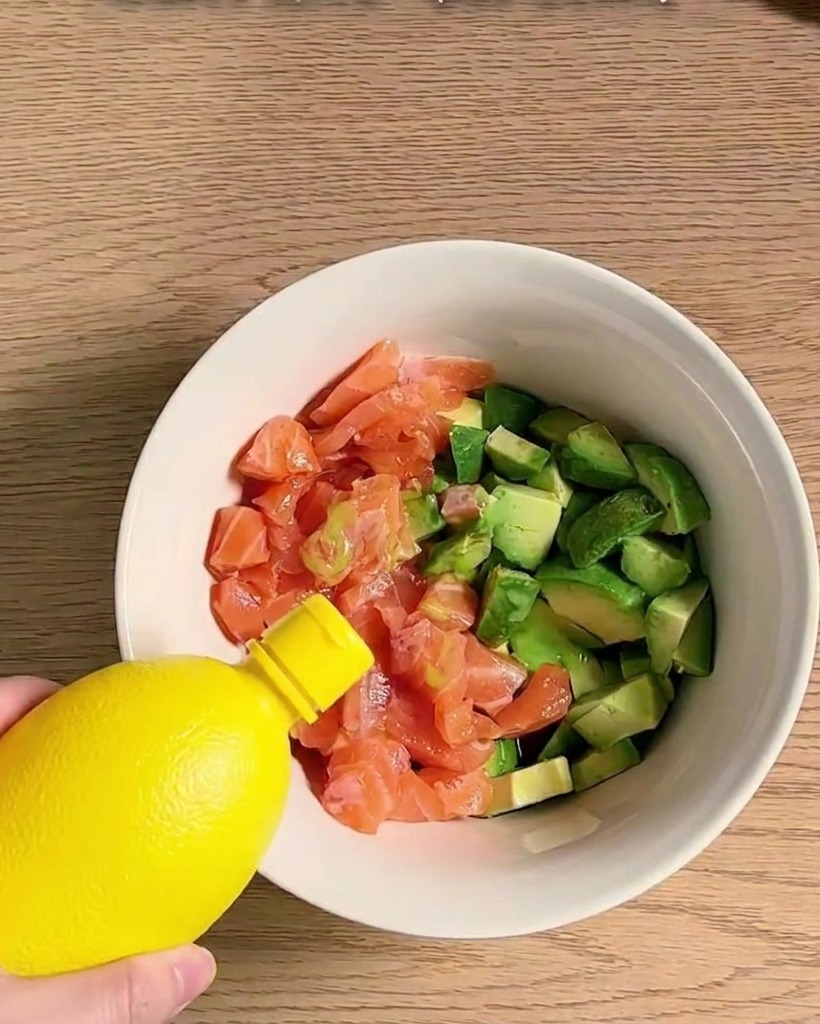 큐브 모양으로 썬 연어와 아보카도에 소스를 넣고 섞는 모습.