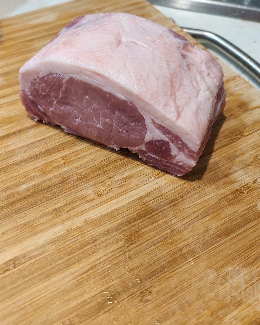 도마 위에서 신선한 삼겹살을 두툼하고 균일하게 써는 모습.