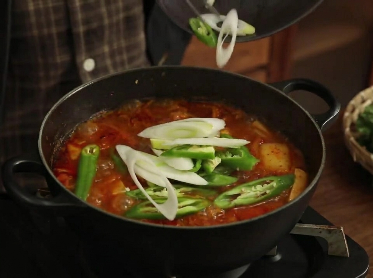 끓는 찌개에 풋고추와 남은 대파를 넣는 모습.