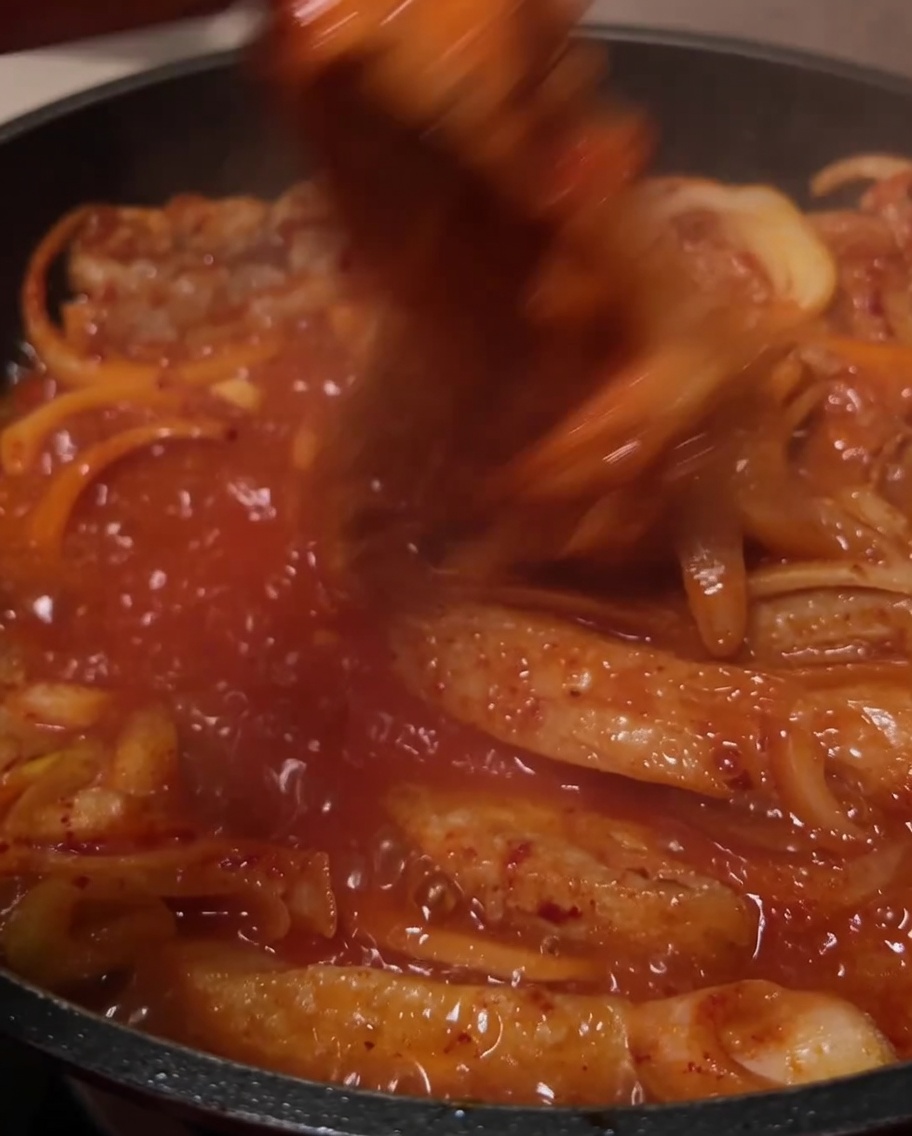 보글보글 끓고 있는 김치찜을 뒤섞는 모습.