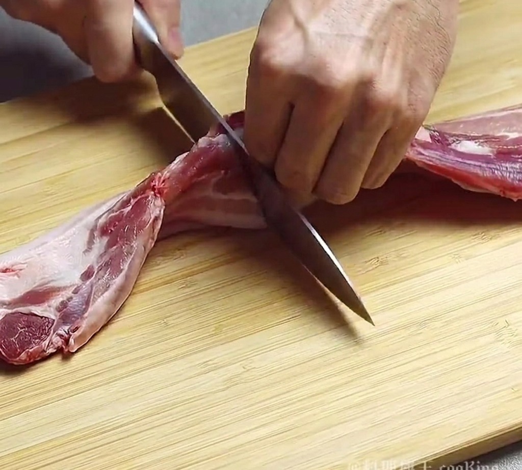 도마 위에서 칼로 삼겹살을 일정한 크기로 써는 모습.