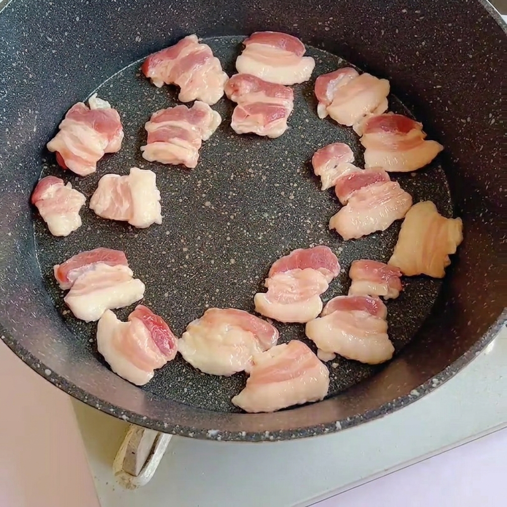 달궈진 팬에 삼겹살을 올려 굽는 모습.