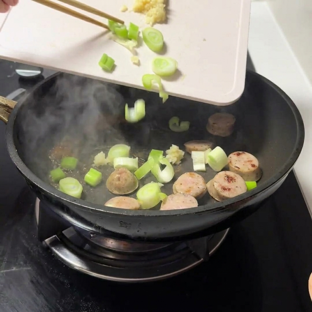 고기와 버터가 담긴 팬에 다진 대파와 마늘을 넣는 모습.