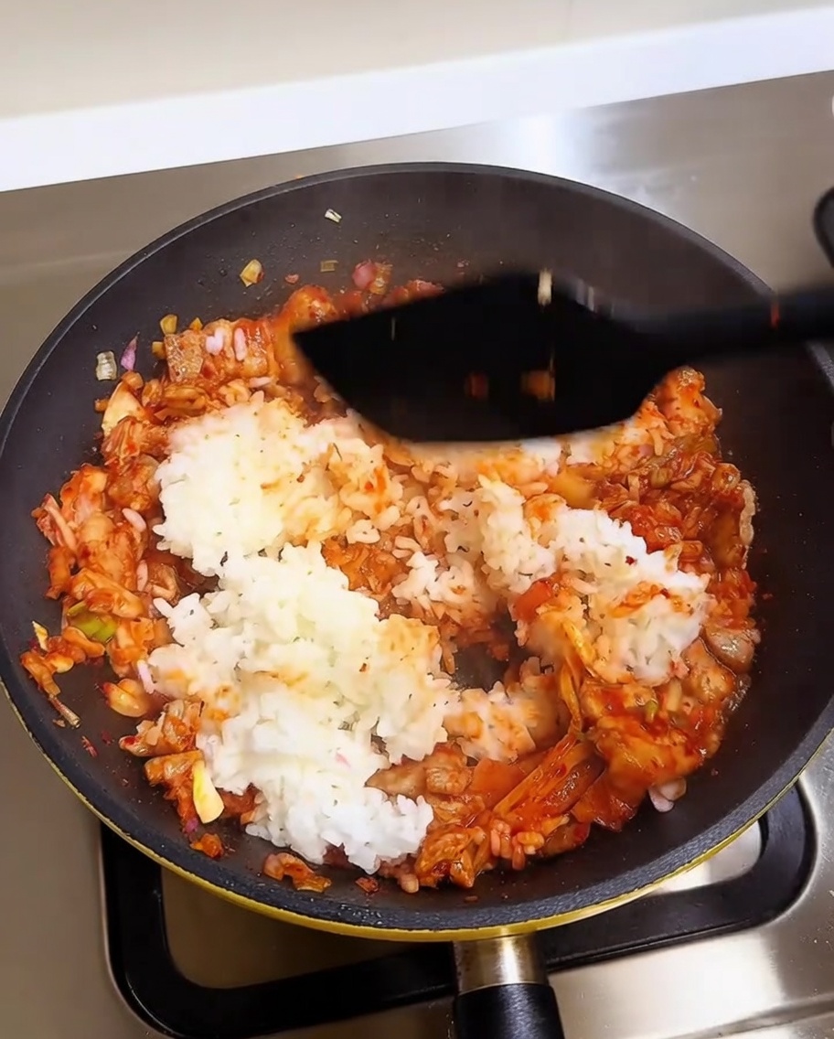 주걱으로 밥과 김치를 맛있게 볶아내는 모습.