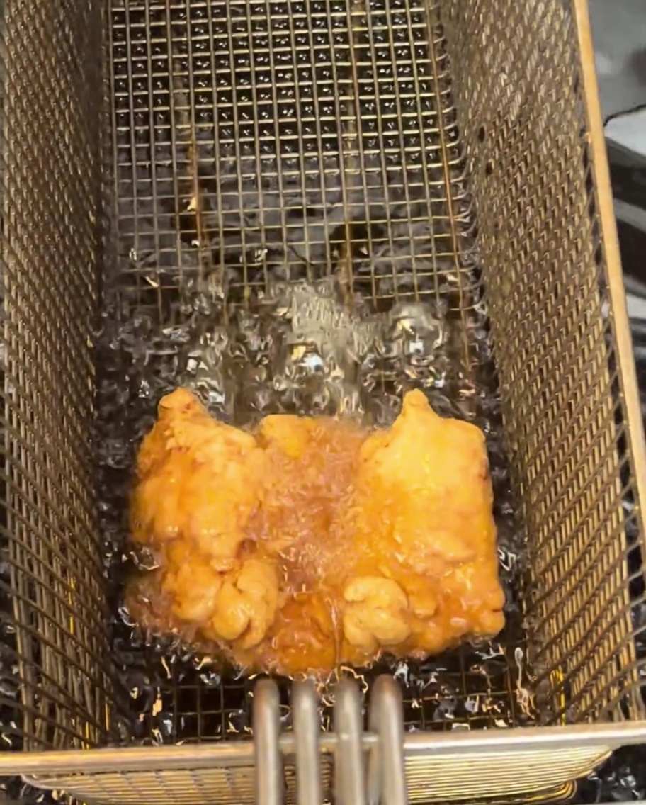 와이어 쿨링 랙 위에 올려진 노릇하게 튀겨진 닭다리살.