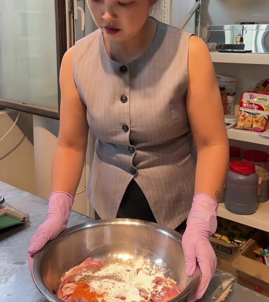 스테인리스 믹싱 볼에 생닭고기와 향신료, 마리네이드 재료를 넣고 섞는 모습