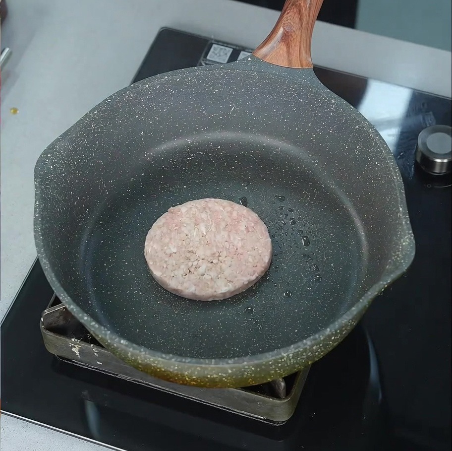 기름을 얇게 두른 팬에서 지글거리며 구워지기 시작하는 소고기 패티.