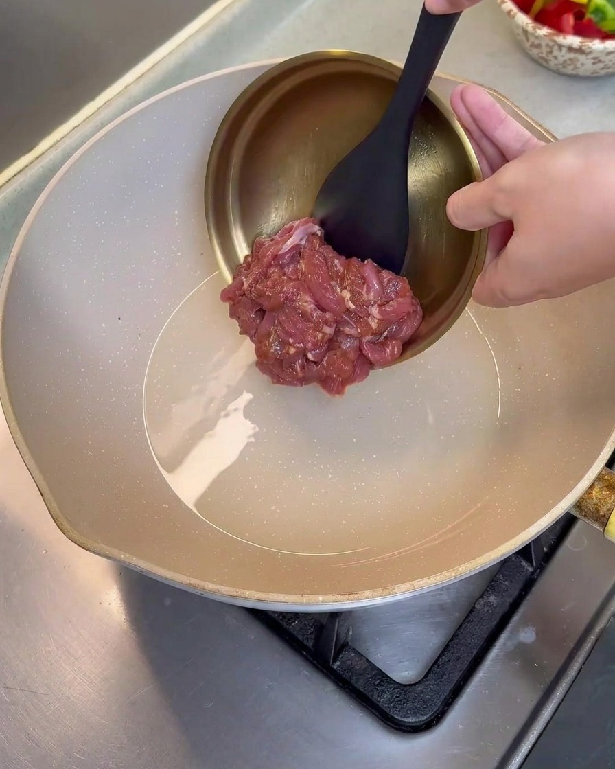 달궈진 팬에 기름을 두르고 밑간한 돼지고기를 넣어 볶는 모습.